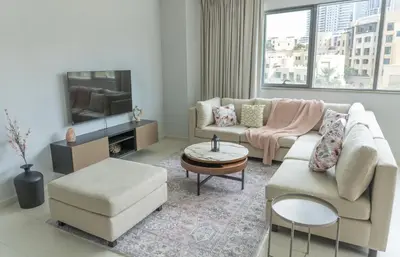 a living room with a couch and a tv at Downtown Oasis, Burj Khalifa Views, Luxury Amenities in Dubai