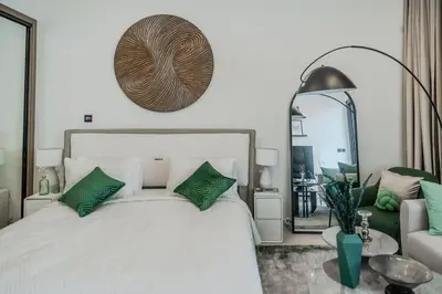 a bedroom with a bed with green pillows and a mirror at Clever Guest 014 Binghatti Canal in Dubai