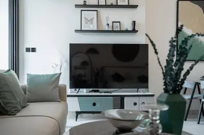 a living room with a couch and a tv at Clever Guest 014 Binghatti Canal in Dubai