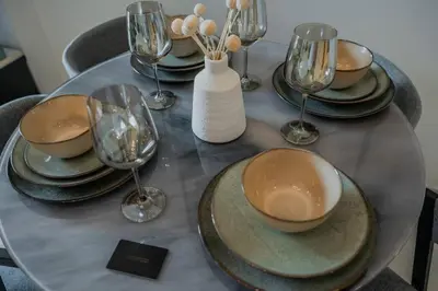 a table with plates and wine glasses on it at Clever Guest 014 Binghatti Canal in Dubai