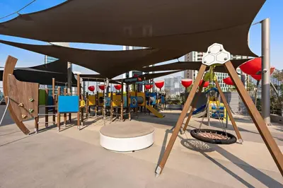 a group of chairs and umbrellas on a playground at Ravishing Studio at MAG 318, Business Bay in Dubai