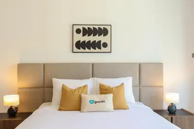 a bedroom with a large white bed with two lamps at HiGuests - City Elegance 1BR in The Sterling by Omniyat in Dubai