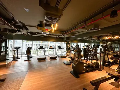 a gym with several treadmills and machines in it at HiGuests - City Elegance 1BR in The Sterling by Omniyat in Dubai