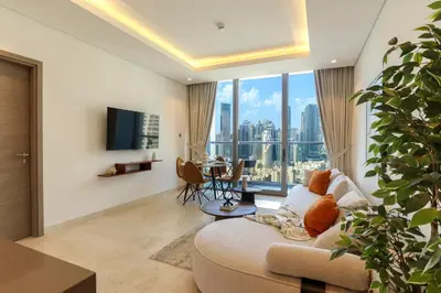 a living room with a couch and a large window at HiGuests - City Elegance 1BR in The Sterling by Omniyat in Dubai