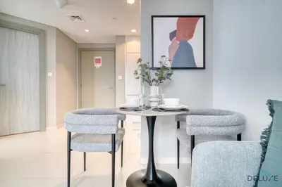 a dining room with a table and two chairs at Canal Views! Promotional Rate on Lovely 1BR by Deluxe Holiday Homes in Dubai
