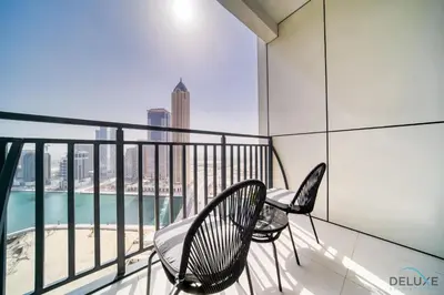 a balcony with two chairs and a view of the city at Canal Views! Promotional Rate on Lovely 1BR by Deluxe Holiday Homes in Dubai