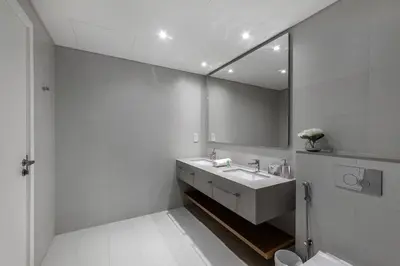 a white bathroom with a sink and a mirror at Luxury apartments at La Vie in Dubai