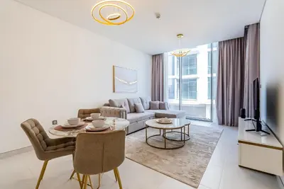 a living room with a couch and a table at District One I MBR I Spacious and Cozy in Dubai