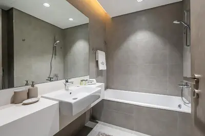 a bathroom with a sink and a bath tub at District One I MBR I Spacious and Cozy in Dubai