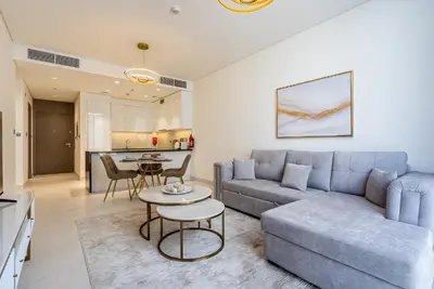 a living room with a couch and a table at District One I MBR I Spacious and Cozy in Dubai