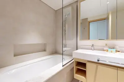 a bathroom with a tub and a sink and a shower at Locations I Creek Harbor I Premium Modern 2BR I Luxury Interiors & Comfortable Stay I Close to Dubai Canal, Dining & Shopping I Pool, Gym & Parking in Dubai
