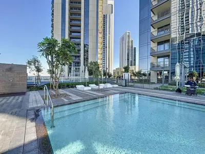 a swimming pool in a city with tall buildings at Locations I Creek Harbor I Premium Modern 2BR I Luxury Interiors & Comfortable Stay I Close to Dubai Canal, Dining & Shopping I Pool, Gym & Parking in Dubai