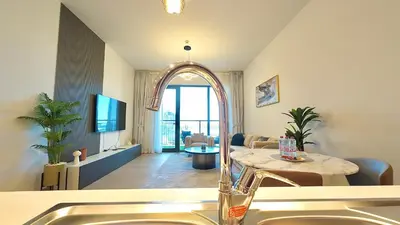 a kitchen with a sink and a living room at Brand New 2BR in La Rive with SeaView, Pool & Gym in Dubai