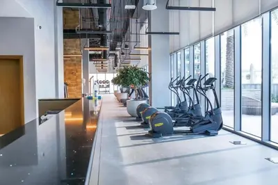 a gym with rows of treadmills and elliptical machines at 2 BR in Forte, Close to Dubai Mall with Pool and Gym in Dubai