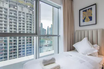 a bedroom with a bed and a large window at Luxe Living in Beachfront 2 Bedroom in Dubai Marina in Dubai