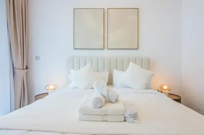a bedroom with a white bed with towels on it at Luxe Living in Beachfront 2 Bedroom in Dubai Marina in Dubai