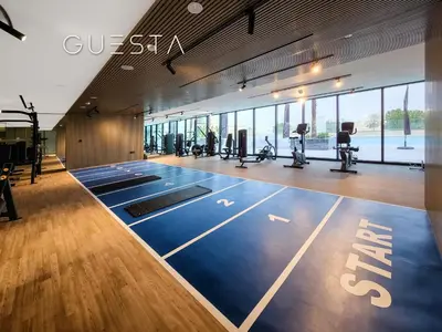 a gym with a gym mats and treadmills in a building at Binghatti Crescent, Jumeirah Village Circle in Dubai