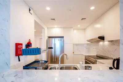 a kitchen with a sink and a refrigerator at Peaceful 2BR Retreat Near Burj Al Arab in Dubai