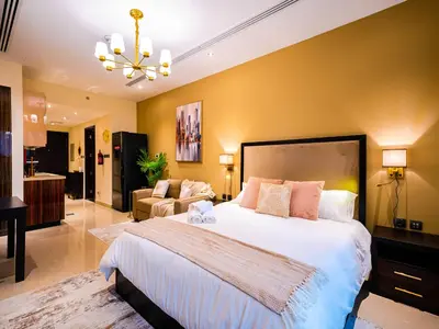 a bedroom with a large bed and a living room at Cozy Studio with Burj Khalifa Views in Dubai