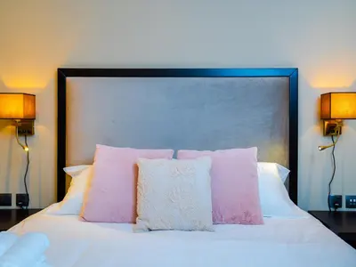 a bed with pink and white pillows on it at Cozy Studio with Burj Khalifa Views in Dubai