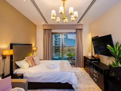 a bedroom with a bed and a large window at Cozy Studio with Burj Khalifa Views in Dubai