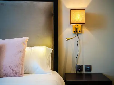 a lamp sitting on a table next to a bed at Cozy Studio with Burj Khalifa Views in Dubai