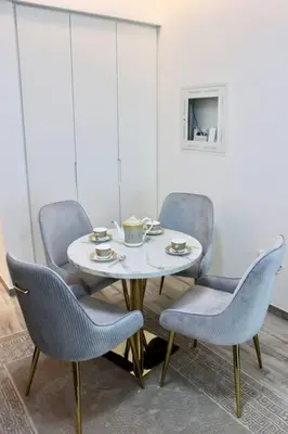 a table with three chairs and a table with tea cups on it at Розкішна квартира з видом на Бурж Халіфа in Dubai