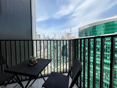 a table and chairs on a balcony with a view of a city at Luxury Studio with Unobstructed Burj Khalifa View - 23AB08 in Dubai