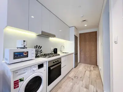 a kitchen with a washing machine and a microwave at Luxury Studio with Unobstructed Burj Khalifa View - 23AB08 in Dubai