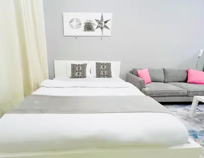 two beds in a living room with a couch at Studio Apartment in Dubai Marina with Balcony in Dubai