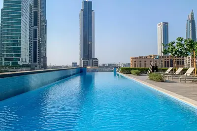 a swimming pool in the middle of a city with tall buildings at Frank Porter - DT1 Tower in Dubai