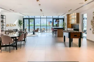 a living room with a table and chairs and a kitchen at Frank Porter - DT1 Tower in Dubai