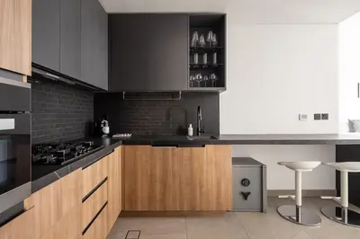 a kitchen with black and wooden cabinets and appliances at Frank Porter - DT1 Tower in Dubai