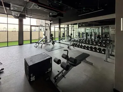 a gym with lots of machines and a simulator at Frank Porter - Prive Residence in Dubai