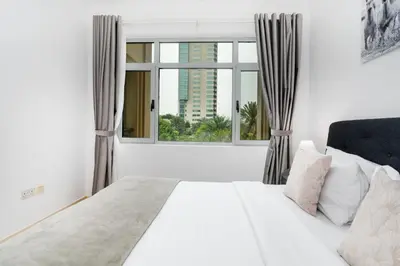 a bedroom with a white bed and a large window at Lux BnB I Turia Tower I Lake & Garden View in Dubai