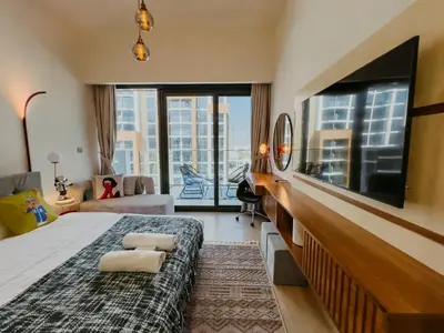 a bedroom with a large bed and a tv at Modern Oasis: Spacious Studio Near Dubai Downtown in Dubai