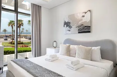a bedroom with a bed with a view of the ocean at 2BR with Sea View & Terrace in Dubai