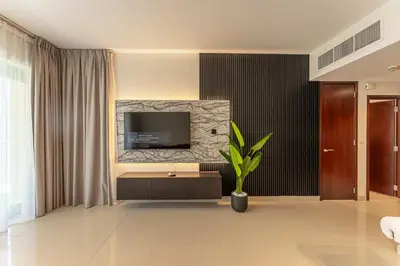 a living room with a television and a plant at Central 1BR with Downtown Fountain Views in Dubai