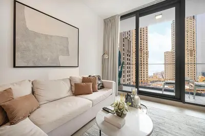 a living room with a white couch and a large window at Sophisticated 1 Bed Suite in Dubai Marina in Dubai