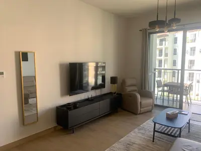 a living room with a tv and a chair and a mirror at les voiles in Dubai