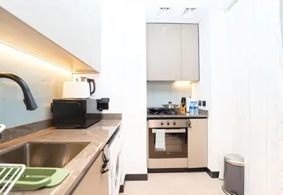 a kitchen with white cabinets and a sink at EasyGo - Northside Tower 2 Canal View in Dubai