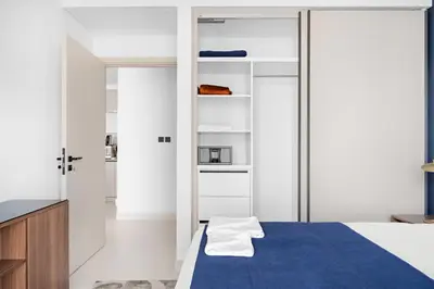 a bedroom with white walls and a blue bed at Silkhaus Sea & Palm View 1BDR at Marina Vista in Dubai