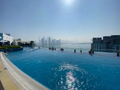 a group of people swimming in a swimming pool at Black and white flower oasis in Seven Palm in Dubai