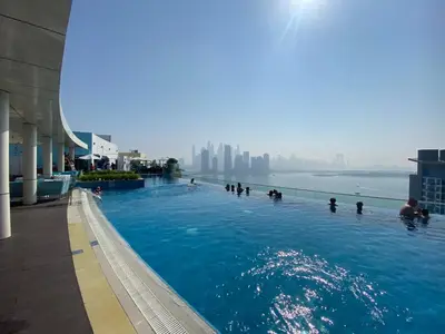 people swimming in a swimming pool in a building at Black and white flower oasis in Seven Palm in Dubai