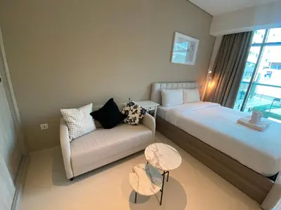 a hotel room with a bed and a couch at Black and white flower oasis in Seven Palm in Dubai