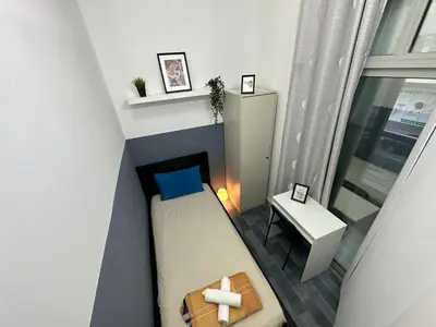 a small room with a bed and a table at Partition Room 5 Mins to Mashreq Metro in Dubai