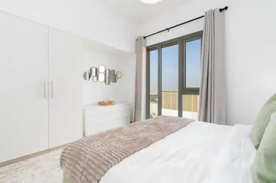 a bedroom with a bed and a large window at UrbanHomes - Exceptional 2 Bedroom Apt in A Family Friendly Neighborhood in Dubai