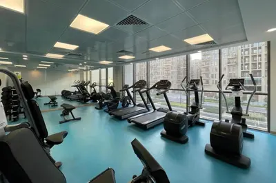 a gym with rows of treadmills and elliptical machines at UrbanHomes - Exceptional 2 Bedroom Apt in A Family Friendly Neighborhood in Dubai