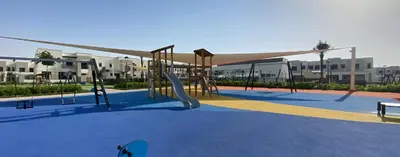 an empty playground with a slide and swings at UrbanHomes - Exceptional 2 Bedroom Apt in A Family Friendly Neighborhood in Dubai