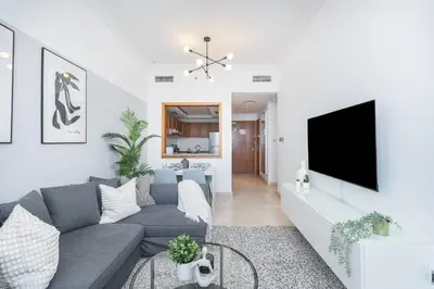 a living room with a couch and a tv at HAVN -1 Bedroom Apartment with Dubai Marina View in Dubai